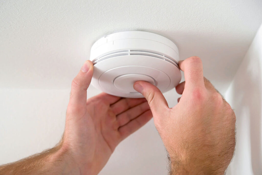 hands installing smoke detector