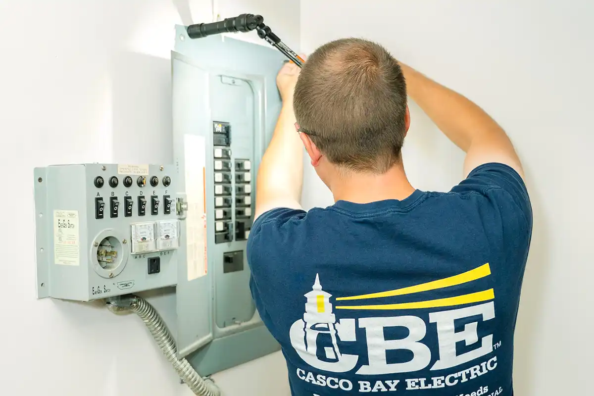 CBE electrician working on breaker box