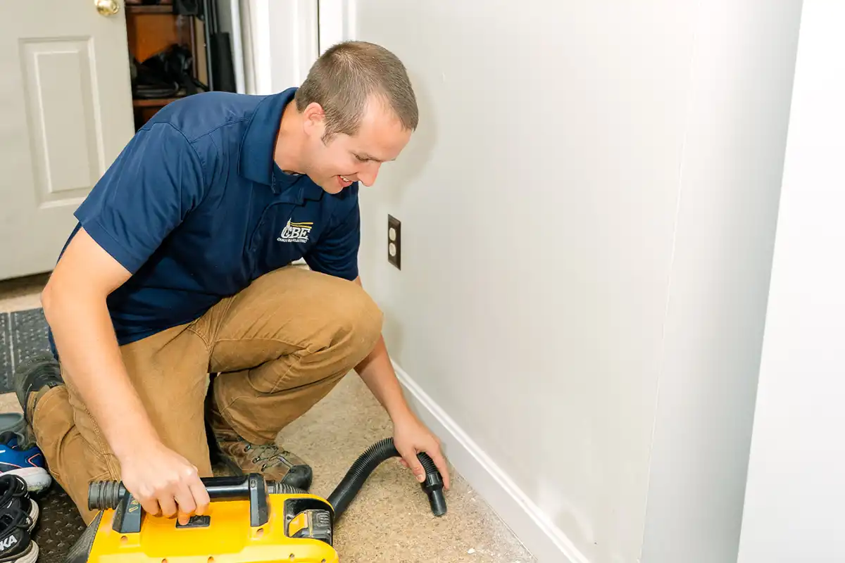 CBE electrician using vacuum on carpet
