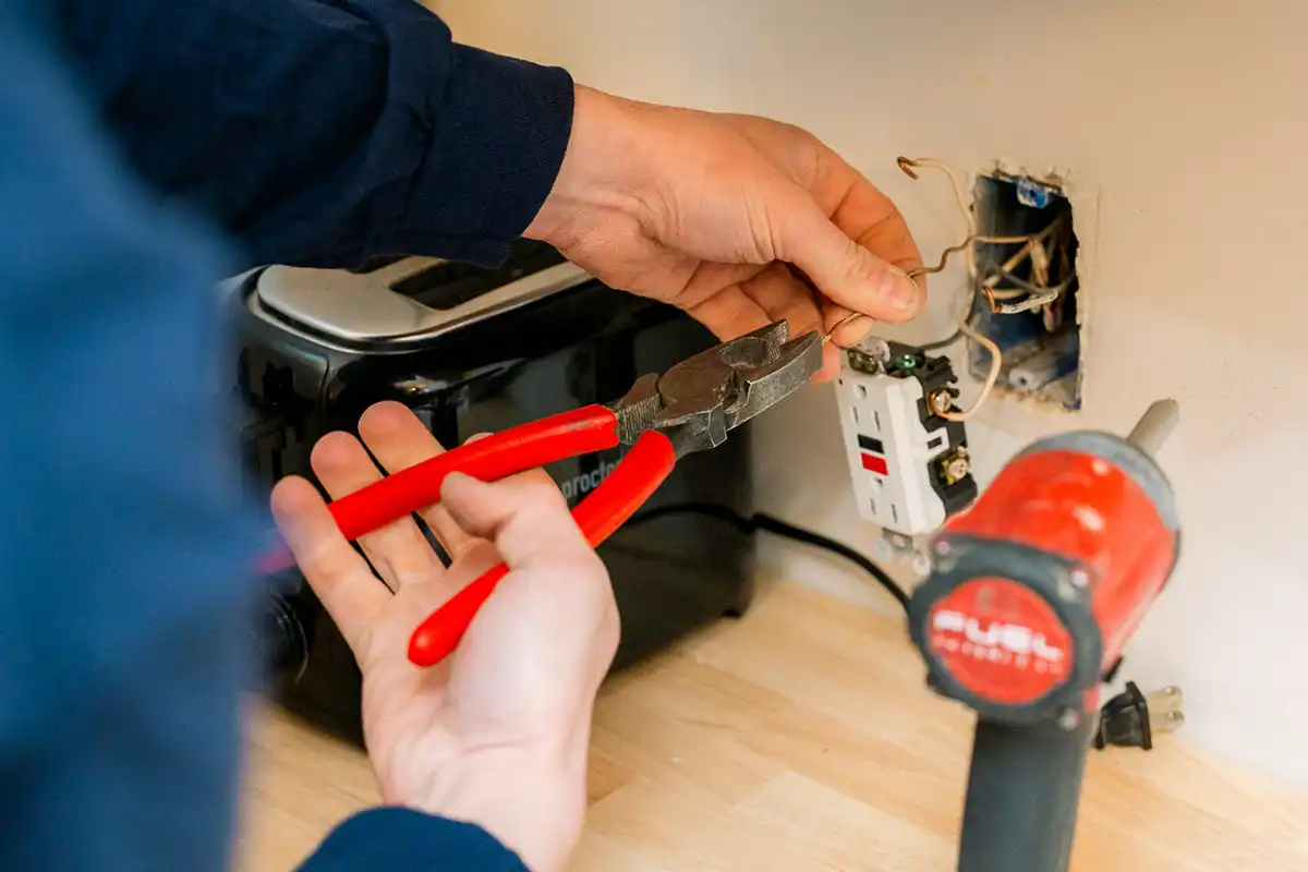 electrician worker on wires from wall outlet